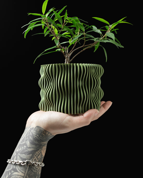 Green 3D printed flower pot held in hand, modern geometric planter for indoor plants