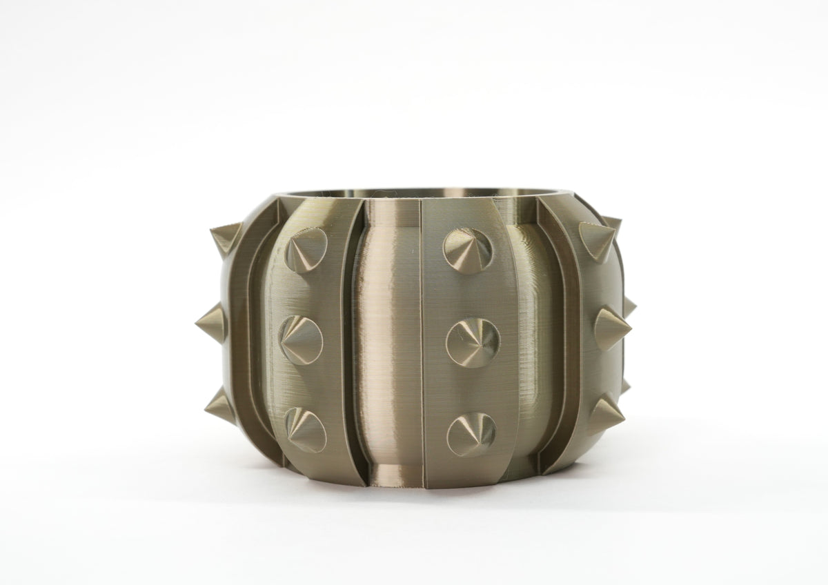 Alver sculptural planter in a metallic finish, shown empty on a light background