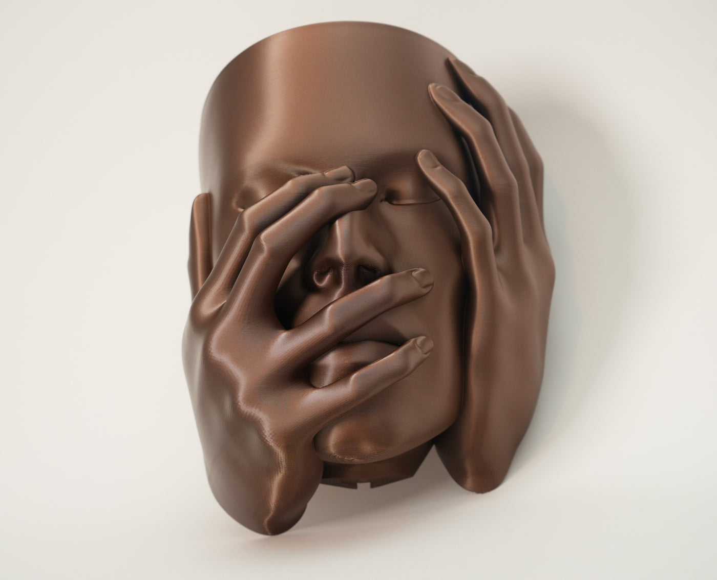 Echo wall planter in warm brown finish with sculptural face and hands covering the eyes