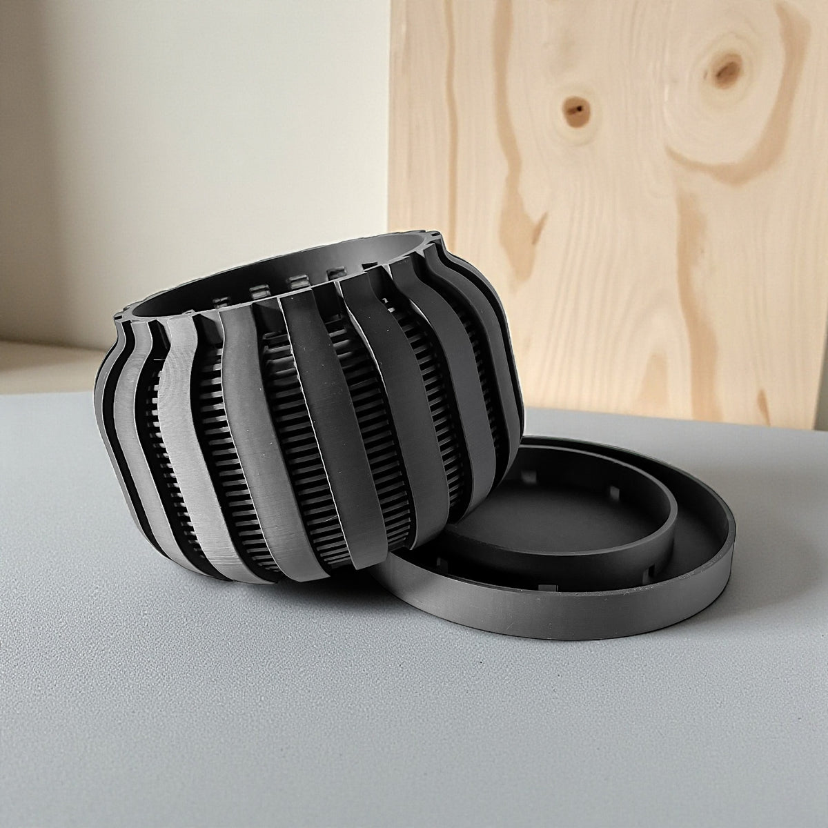 Avix ventilated orchid pot with rounded ribs, angled view beside separate tray