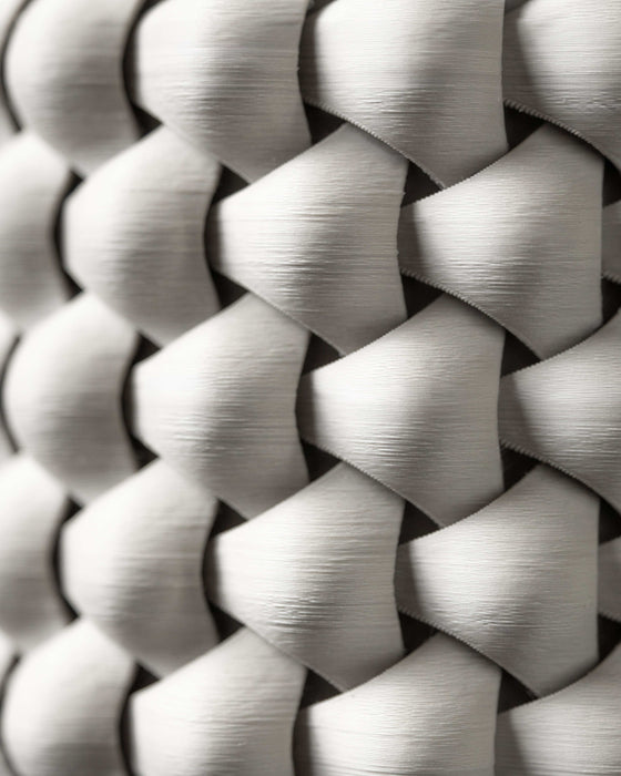 Close-up of white 3D printed planter surface, showing highly detailed interlaced texture with concave diamond-shaped units creating a dynamic shadow play; the filament lines highlight precision printing, and the tactile quality of the thick braided design is clearly visible.