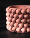 Terracotta 3D printed planter with cylindrical body and bold braided design; close-up highlights warm earthy tone and tightly layered diamond segments with soft sheen from filament lines.