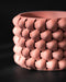 Terracotta 3D printed planter with cylindrical body and bold braided design; close-up highlights warm earthy tone and tightly layered diamond segments with soft sheen from filament lines.