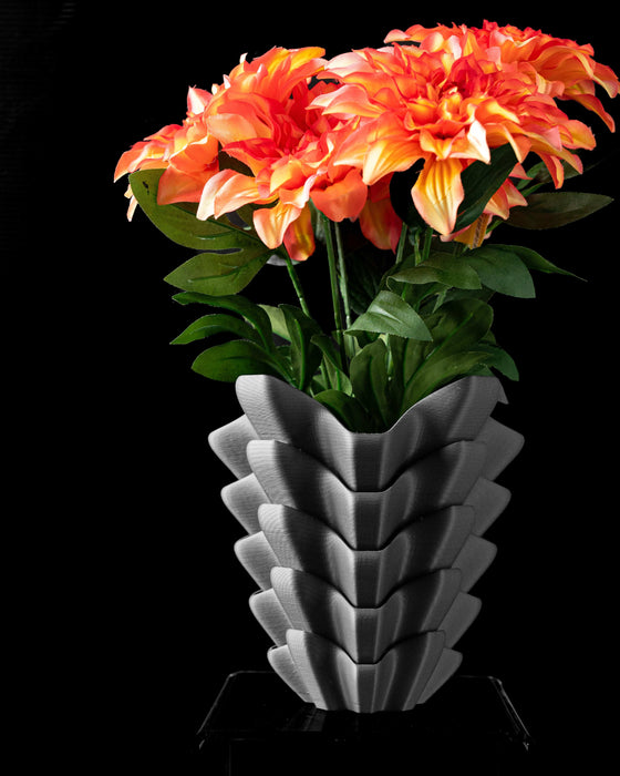 3d printed vase in black color with futuristic angular form and vertically stacked contours, black vase with symmetrical sculptural folds and soft light reflections, flower vase for dried flowers or curated arrangements, personalized vase with layered geometry for unique gift or home styling, vases for flowers with bold texture and modern silhouette, minimalist ikebana vase for tabletop or home office decor