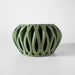 Minimalist tabletop pot with airy cutout pattern and curved shape, futuristic home decor accent