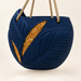 Front view of the empty navy Aurelia hanging planter, showing sculpted leaf veins, two gold-tone inlays and tan rope.