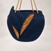 Angled view of the navy Aurelia hanging plant pot with leaf relief and gold-tone accents.