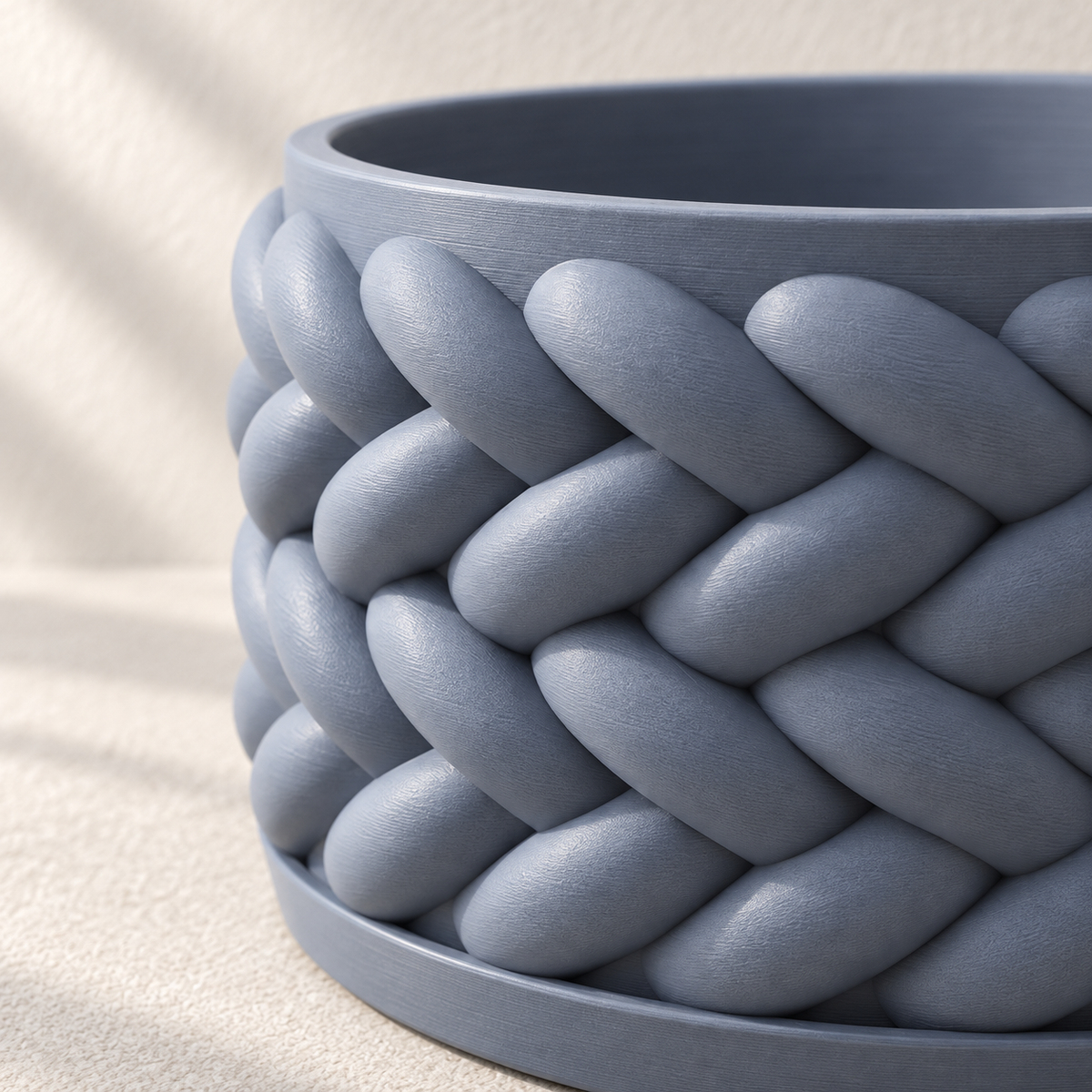 Close-up of the overlapping braided relief and smooth rim on a blue Braido bonsai planter.