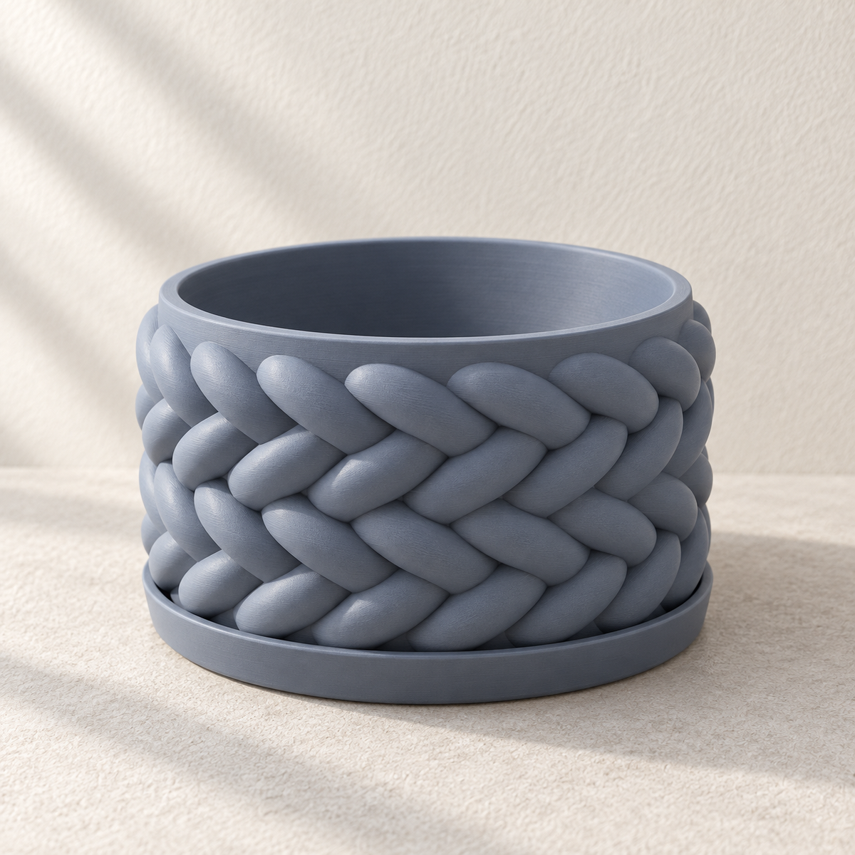 Empty blue Braido bonsai planter with broad woven relief, seated on its matching shallow tray.