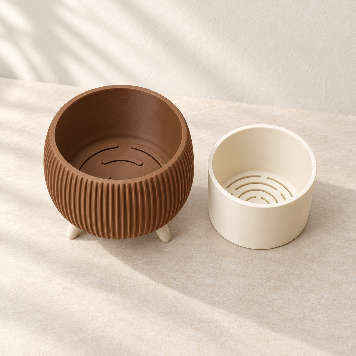 Brown Arco bonsai planter beside its cream removable insert, showing curved drainage slots inside.