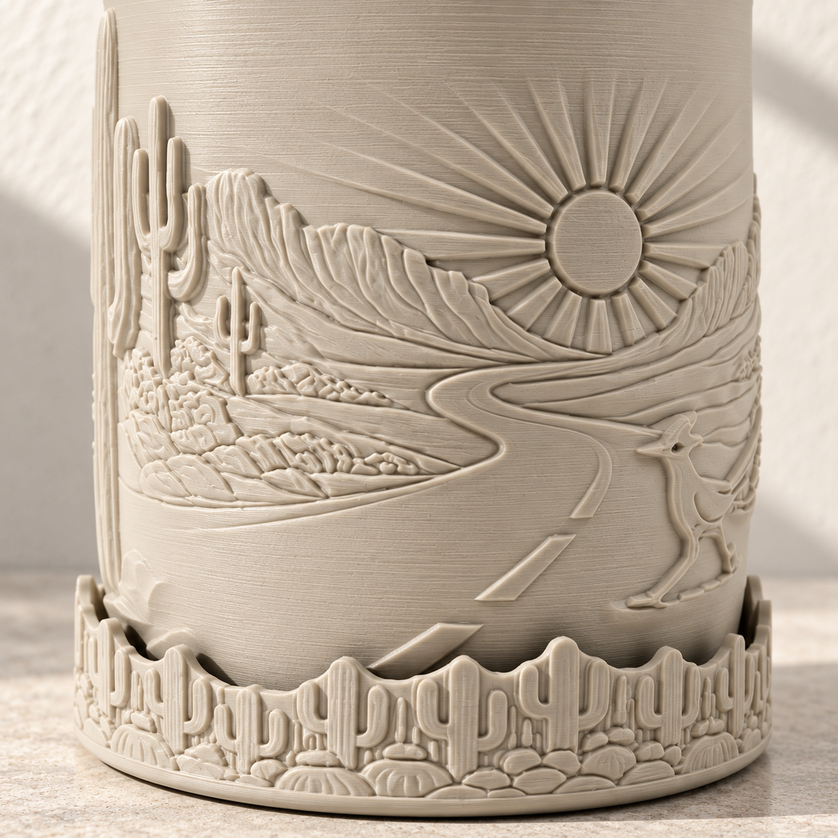 Close-up of the sun, winding landscape and cactus-patterned lower base on the Desert Sunrise planter.