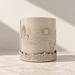 Empty cream Desert Sunrise planter with a raised sun, winding desert landscape and cactus-patterned base.