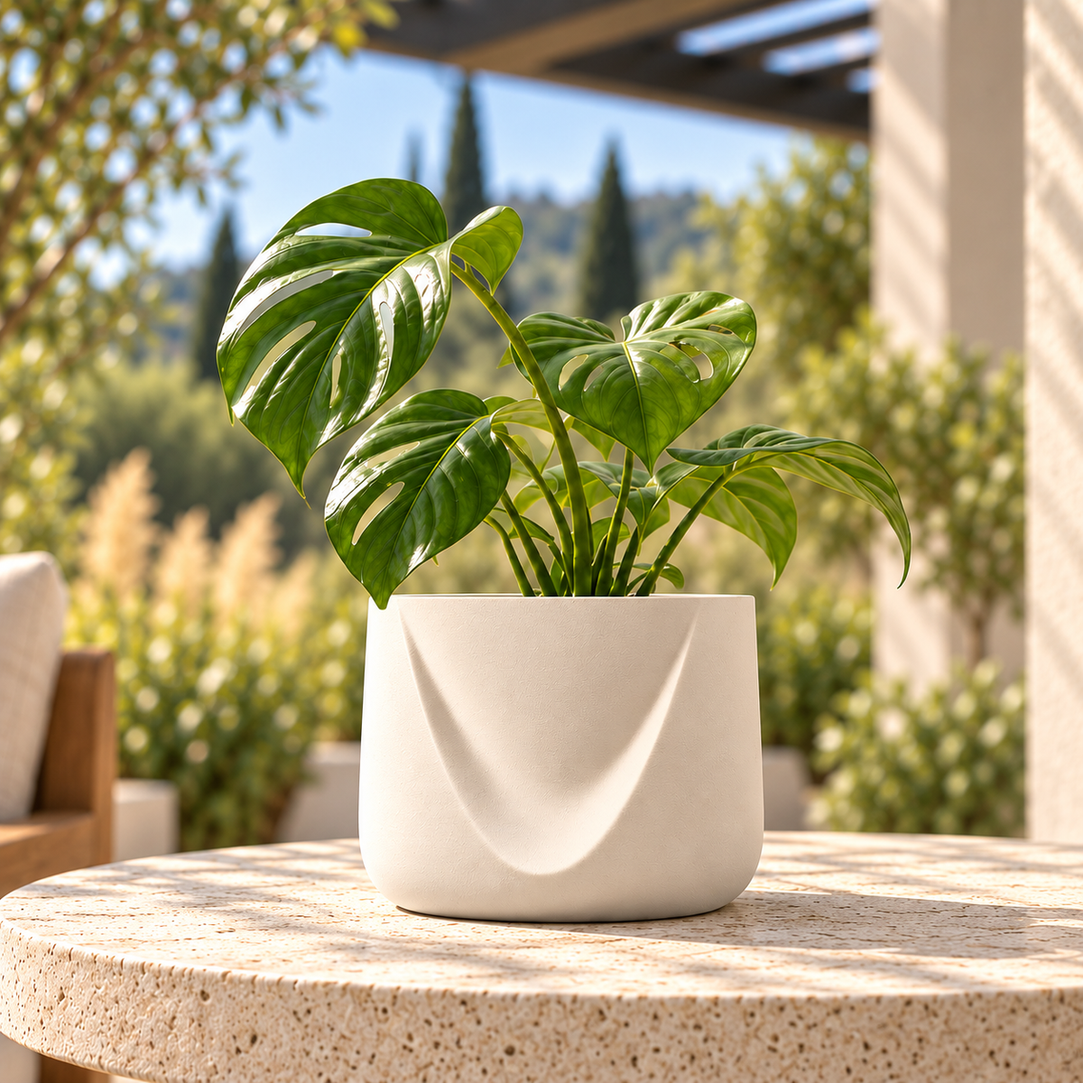 Drape outdoor ASA planter in Natural with green foliage, centered on a sunlit stone patio table.