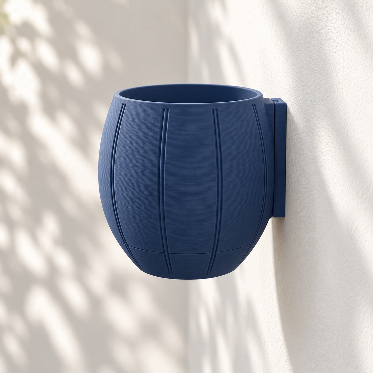 Empty navy Duoro wall planter mounted against a light wall, showing the curved body and rear mounting plate.