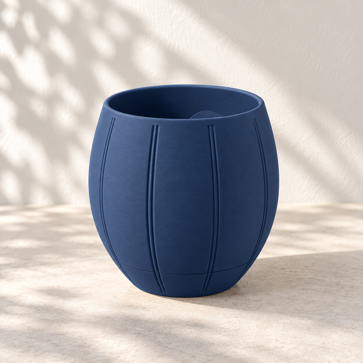 Front view of the navy Duoro round wall planter with paired vertical grooves and a lower collector seam.