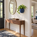 Navy Duoro wall planter with golden pothos in a bright entryway beside a mirror and wooden console.