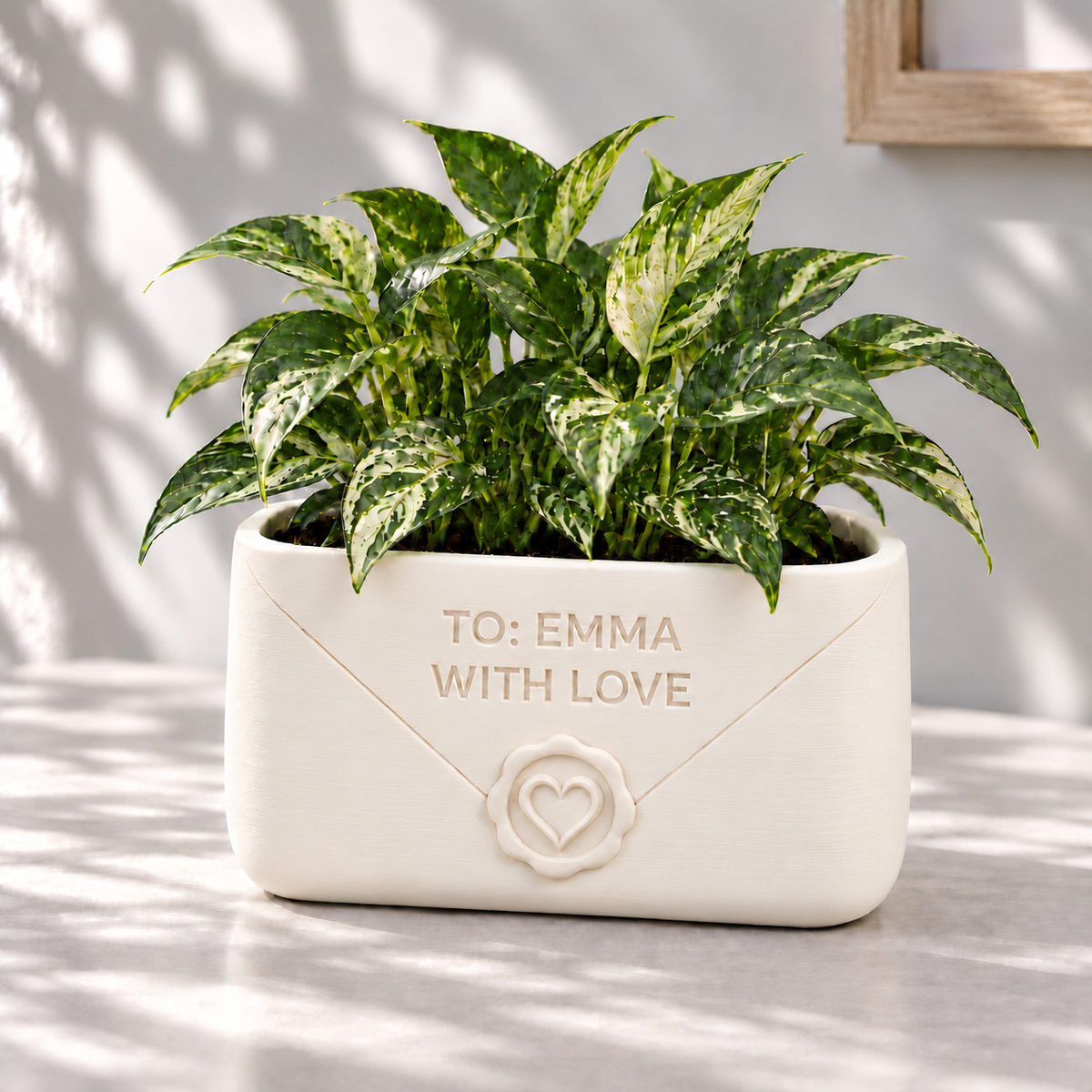 Cream Envio envelope planter with a heart seal, personalized front message and a variegated houseplant.