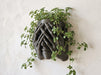 Sculptural face wall planter mounted with a trailing indoor plant as modern plant wall decor