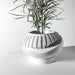 Side angle close-up highlighting sleek layered texture and tilted oval shape of contemporary planter pot, stylish geometric succulent planter, artistic decorative flower pot, modern tabletop indoor pot, sculptural 3D printed planter