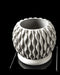 High-contrast image of a matte gray planter viewed from above, revealing the depth of its cylindrical container and beveled rim. Its upper section showcases a fine-grained texture that mimics natural stone, while the lower platform incorporates polygonal architectural openings. The planter exemplifies how 3D printing allows form and function to merge in a single sculptural object ideal for modern and industrial-inspired settings.