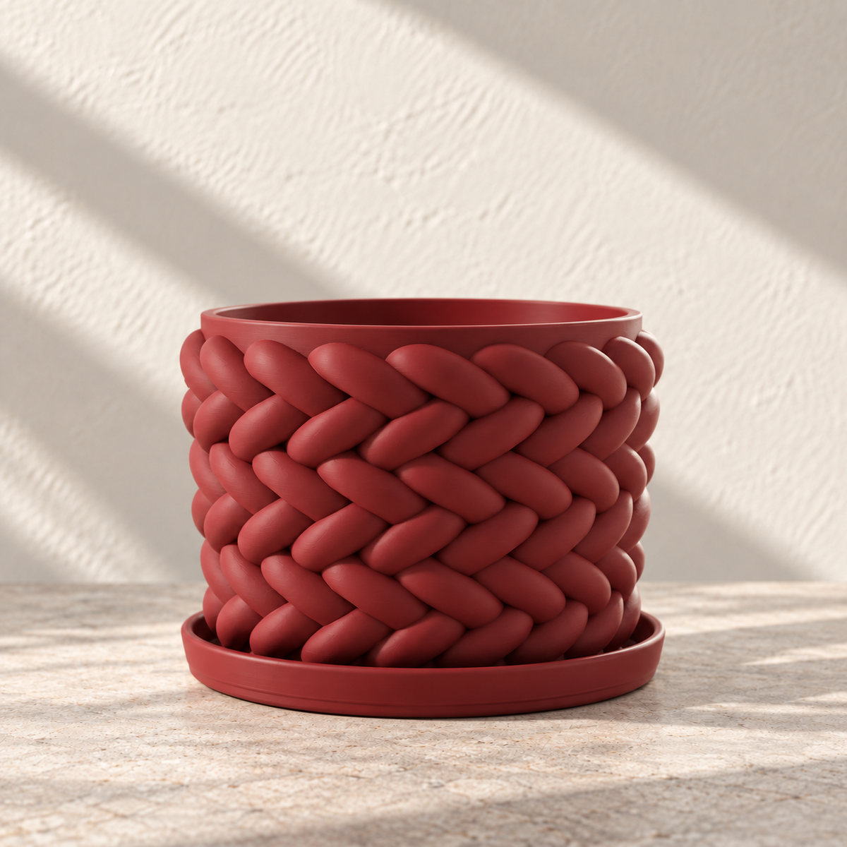 Empty red Braido woven planter resting on its matching round tray.