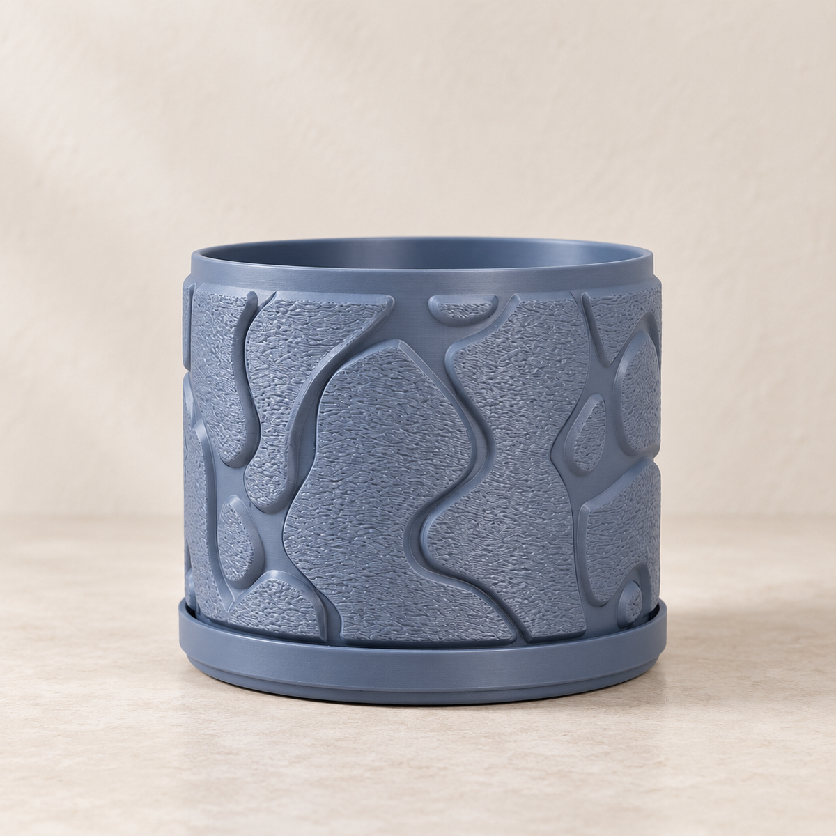 Flow indoor planter showing broad raised wave lines around the cylindrical body