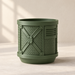 Industrial planter showing cylindrical body, rivet-like accents, and raised bands