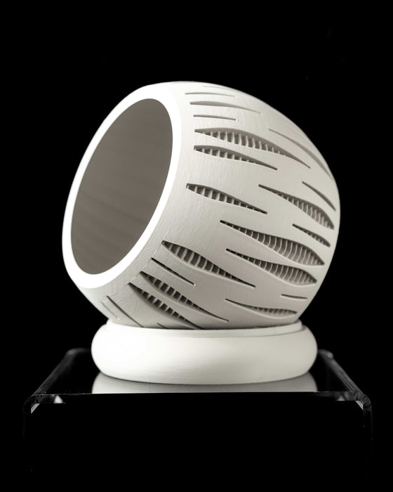 white spherical planter with elongated perforations, intricate inner structure shown through external cuts, paired with curved matching drainage saucer, displayed on acrylic stand, 3D printed planter, unique gift idea, pot with drainage, for contemporary plant styling