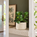 Front view of Tropica round planter with large overlapping tropical leaf relief