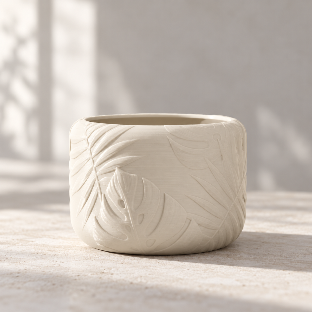 Decorative Tropica round planter with raised botanical leaf pattern and houseplant