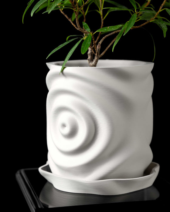 modern white planter with sculptural ripple texture imitating water impact, vertically elongated form with subtle deformation, 3d printed from biodegradable material, paired with curved drainage tray, close-up showcasing natural light and shadow play on textured surface, artistic geometric home decor accent, ideal for succulents or indoor greenery, futuristic and soft-edged design language