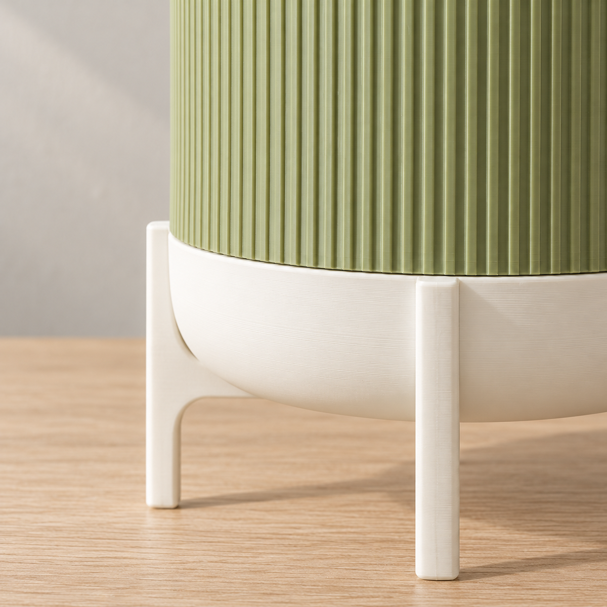 Close-up of green Rialto ribbing above the smooth white lower bowl and slim supporting legs.