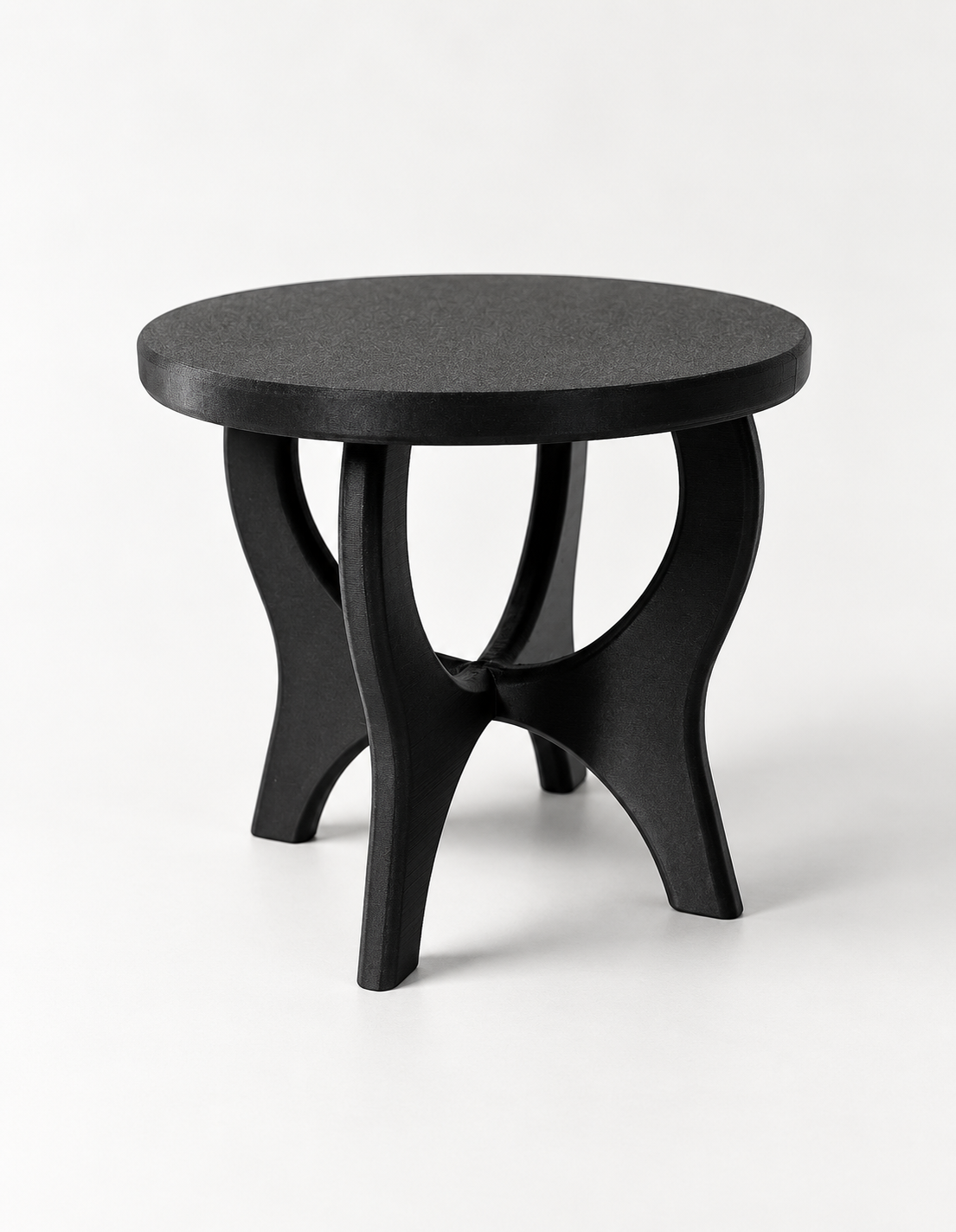 Angled view of the empty black Curvelift stand showing its intersecting curved legs beneath a round platform.