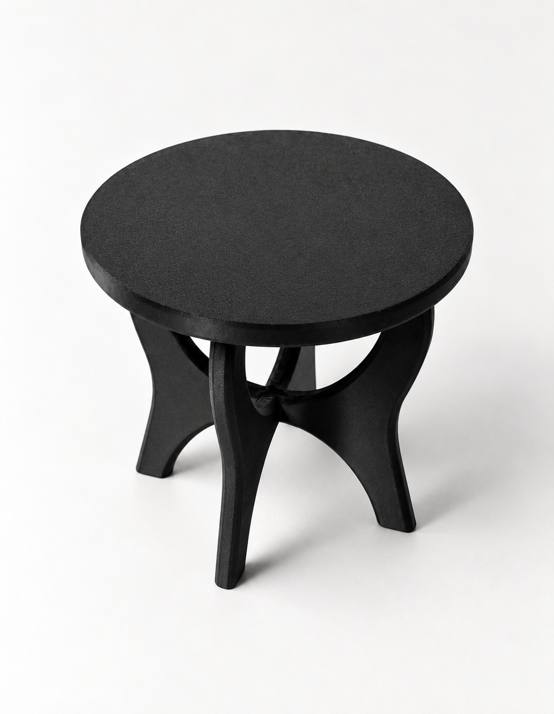 Top view of the black Curvelift stand showing its solid round platform and sculpted supports below.