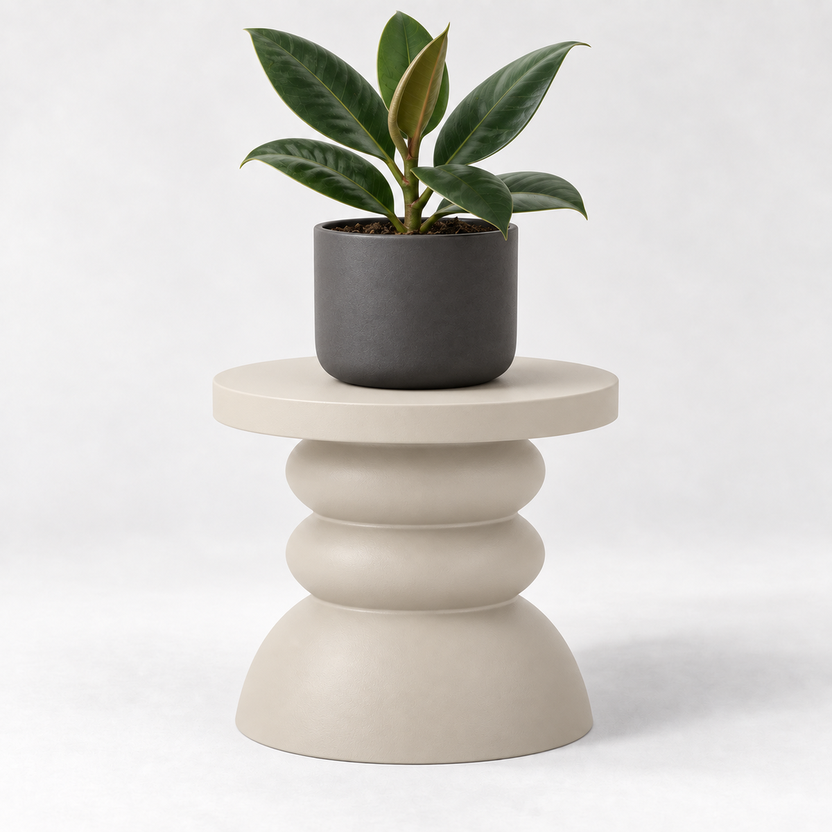 Cream Moro pedestal plant stand with stacked rounded contours supporting a gray pot with dark green leaves.