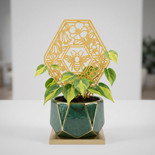 Plant trellis “Bela” with bee and floral honeycomb design supporting an indoor climbing plant