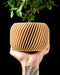 Rivo low-profile round planter showing sweeping diagonal ribs