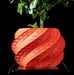 A vivid coral red planter pot with sculptural details, resting on a matching base. This 3D printed planter is perfect for succulents, bonsai, or indoor greenery, adding a modern twist to traditional flower pots. Great for unique home decor, gifts for mom, or book plant pot display, it's a standout among indoor planters and low planter pots with unique flair.