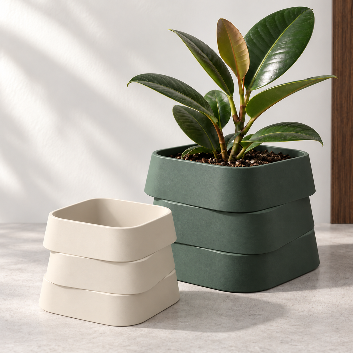 Design visualization of a Forest Green three-tier planter with a rubber plant, beside a smaller empty Cream White planter at the front-left on a pale gray surface.