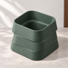 Design visualization of an empty Forest Green planter with three offset rounded-square tiers, viewed from above on a pale gray surface against an off-white wall.