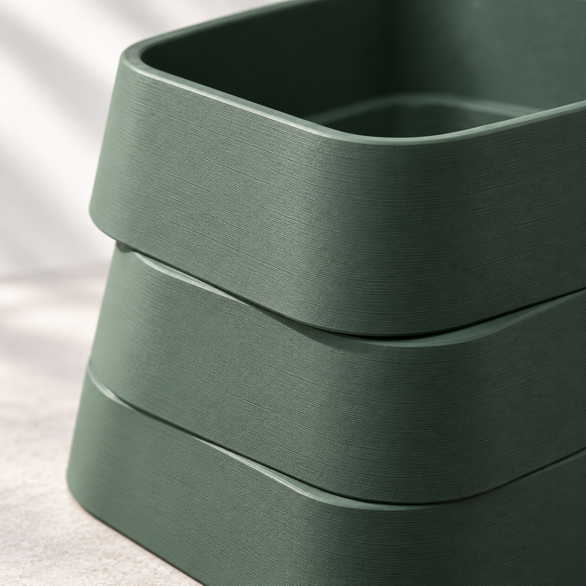 Design visualization showing the rounded corners, offset tier edges, and fine horizontal layer texture on a matte Forest Green planter in close-up.