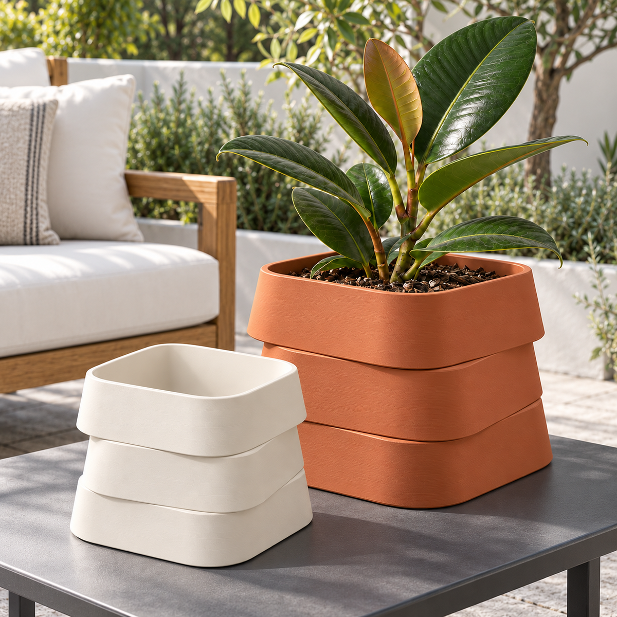Outdoor design visualization of a Terracotta three-tier planter with a rubber plant beside a smaller empty Natural White planter on a charcoal patio table.
