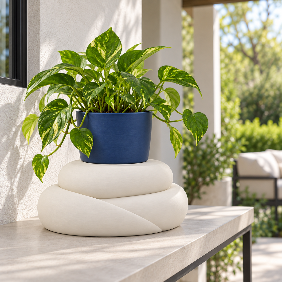Cream White Talvo stand with a navy planter on a covered terrace.