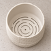 Top view inside an empty Tessaro wall planter showing the smooth inner walls, curved drainage slots and small center opening.