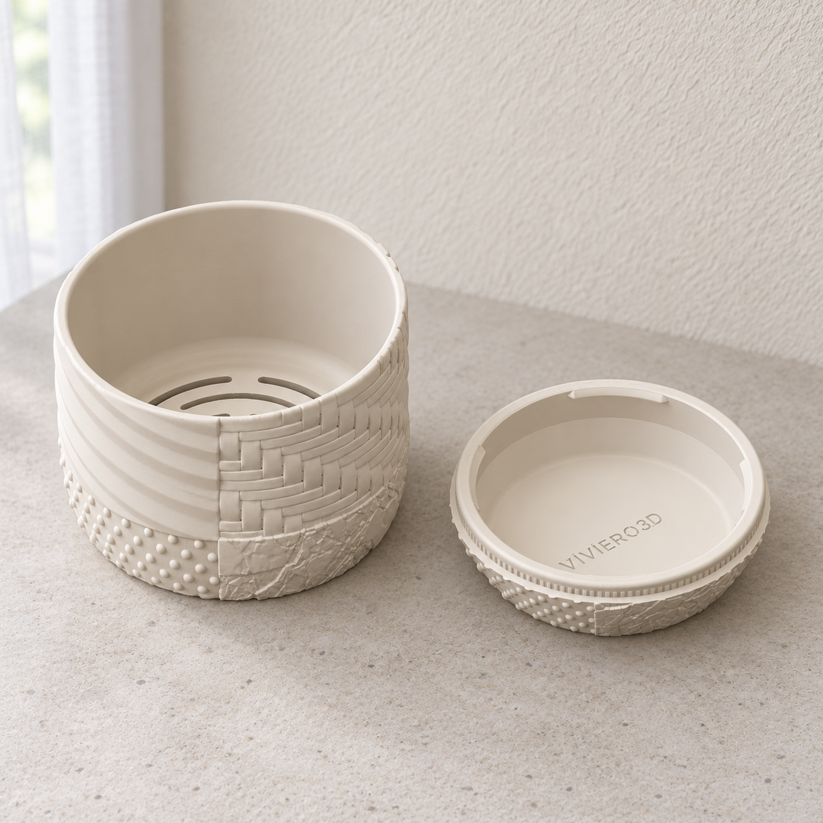 Tessaro wall planter beside its detached matching drainage tray, with curved drainage slots visible inside the planting section.