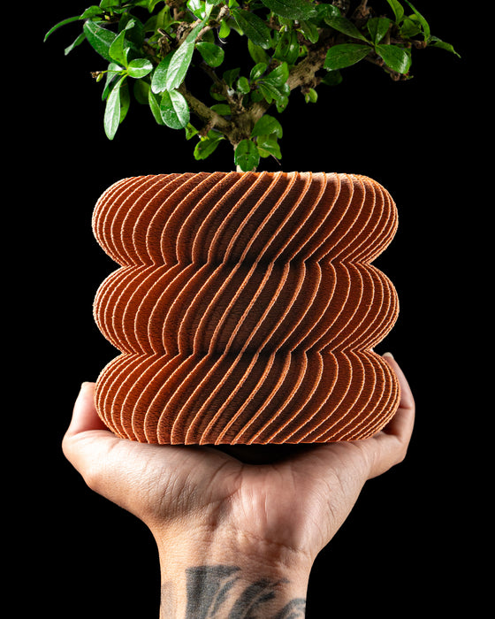 Toren spiral ribbed LUX planter with plant, handheld front view