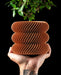 Toren spiral ribbed LUX planter with plant, handheld front view