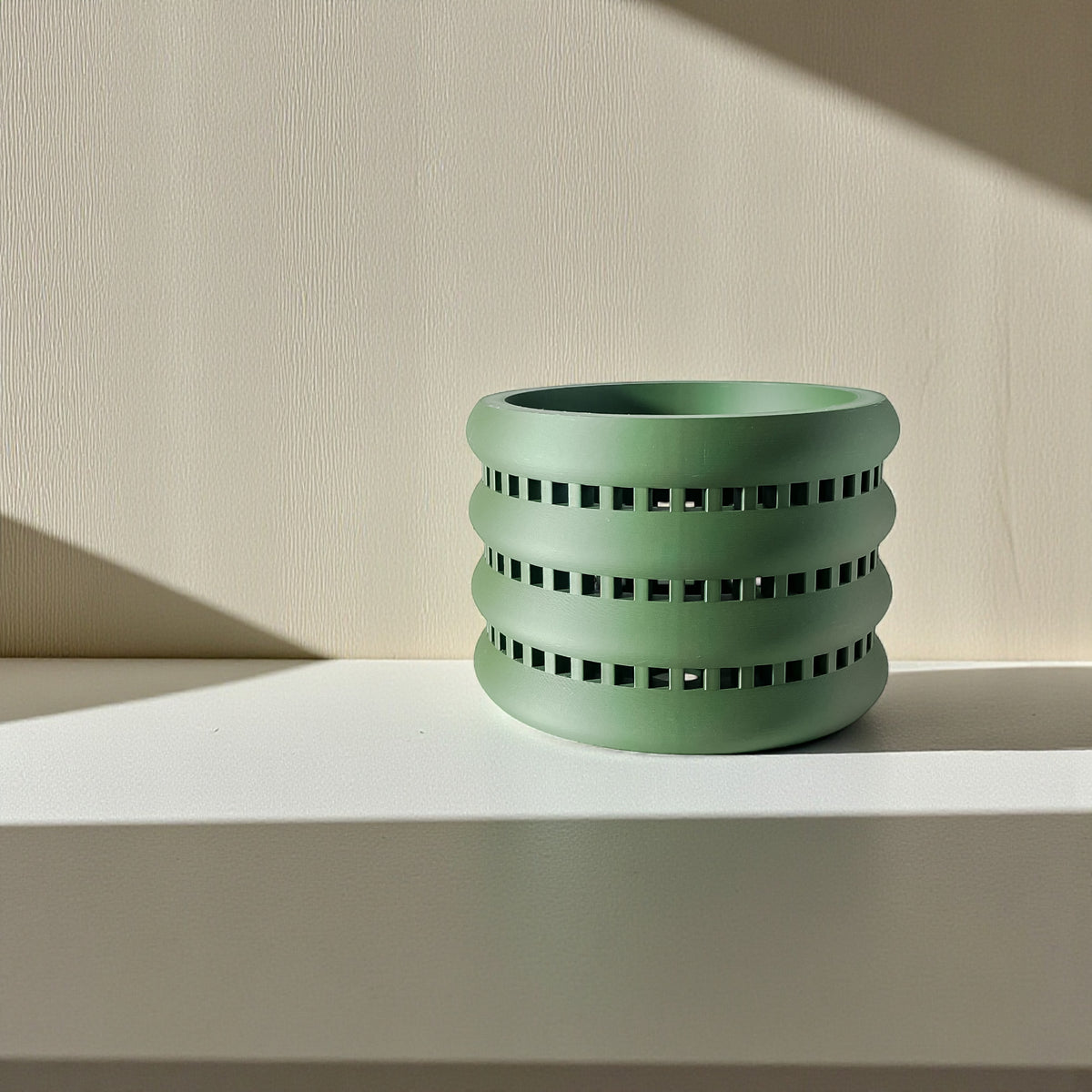 Ulra ventilated orchid pot with horizontal bands, empty pot on a light shelf