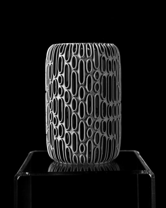 artistic 3d printed vase in black with geometric oval reliefs circling its surface, sculptural flower vase combining art and function, black vase perfect for dried flowers or decorative twigs, sleek contemporary decor item with dimensional texture and clean vertical build, cylinder vase with repeating open cutouts, striking design for modern interiors, vase dried flowers, modern vase, vases for flowers, black vase, home office decor, 3d printed vase