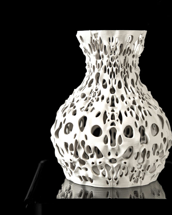 Aesthetic white vase crafted with numerous irregular cutouts and undulating 3D-printed surface layers; the model blends modern sculpture with practical floral use, offering a rounded body and slightly flared top; each hole is uniquely shaped, creating a biological, natural rhythm in the design; best used for dried flowers, decorative stems, or curated floral arrangements in bold modern interiors.